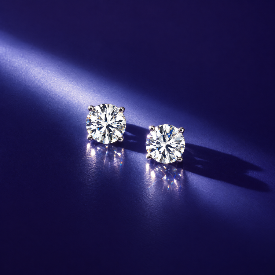 Pair of 1 carat round lab-grown diamond stud earrings in 14K white gold, four-prong settings, indigo background, AI-generated image — DEEVE