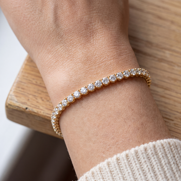 Close-up of a 4 carat lab-grown diamond tennis bracelet in 14K yellow gold worn on the wrist, AI-generated image — DEEVE