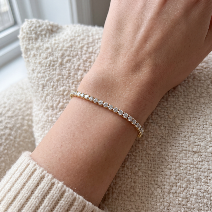 Close-up of a 5 carat lab-grown diamond tennis bracelet in 14K yellow gold worn on the wrist, AI-generated image — DEEVE