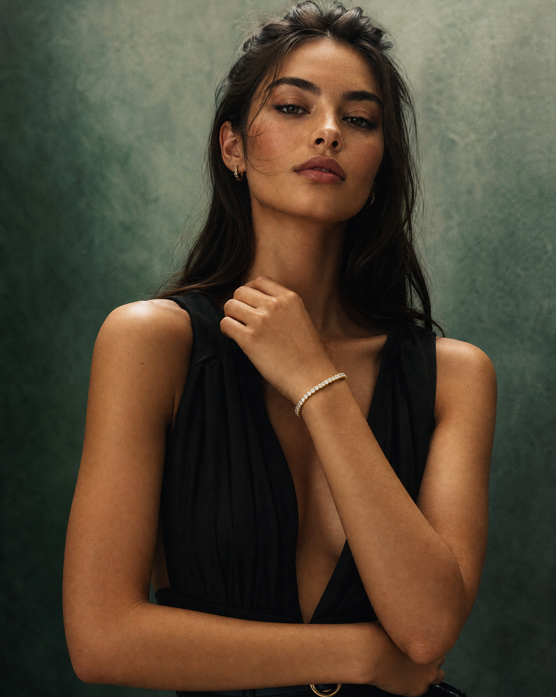 Woman in a black dress wearing a diamond tennis bracelet and gold hoop earrings