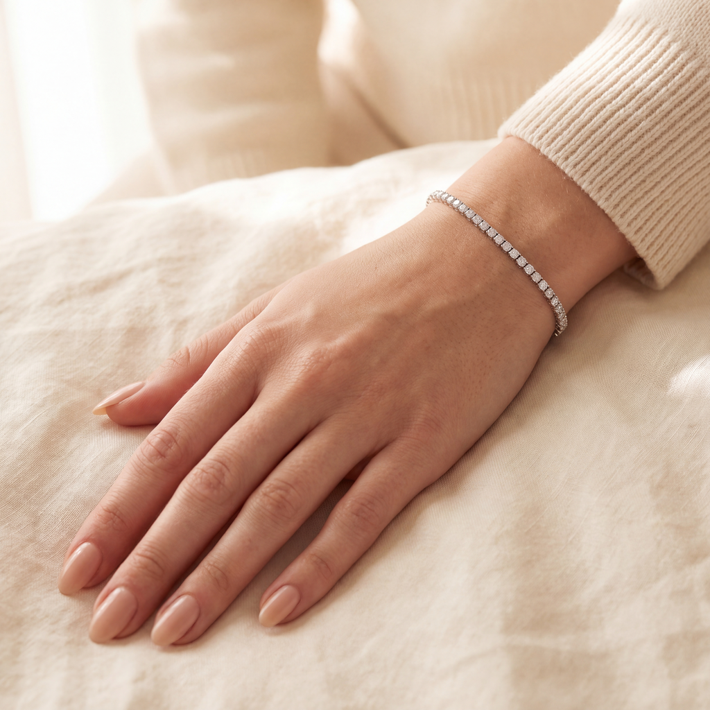 2 carat lab-grown diamond tennis bracelet in 14K white gold worn on the wrist, hand resting on a cream linen sheet, AI-generated image — DEEVE