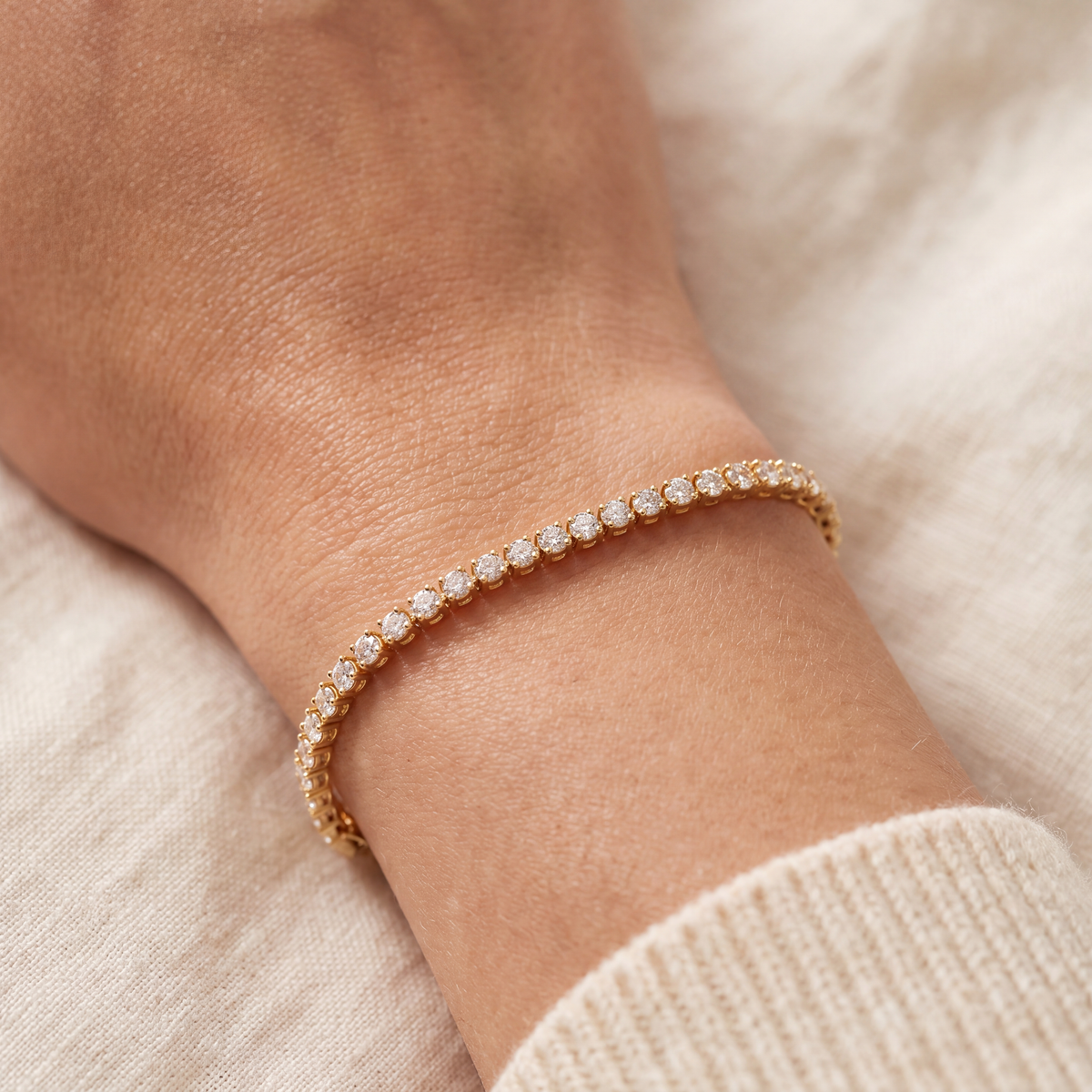 Close-up of a 2 carat lab-grown diamond tennis bracelet in 14K yellow gold worn on the wrist, AI-generated image — DEEVE