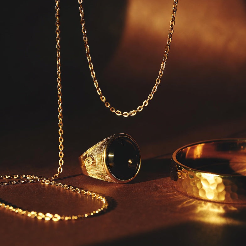  men's 14k solid Gold chain and fine gold ring on a dark surface with warm lighting, DEEVE's men gold jewelry
