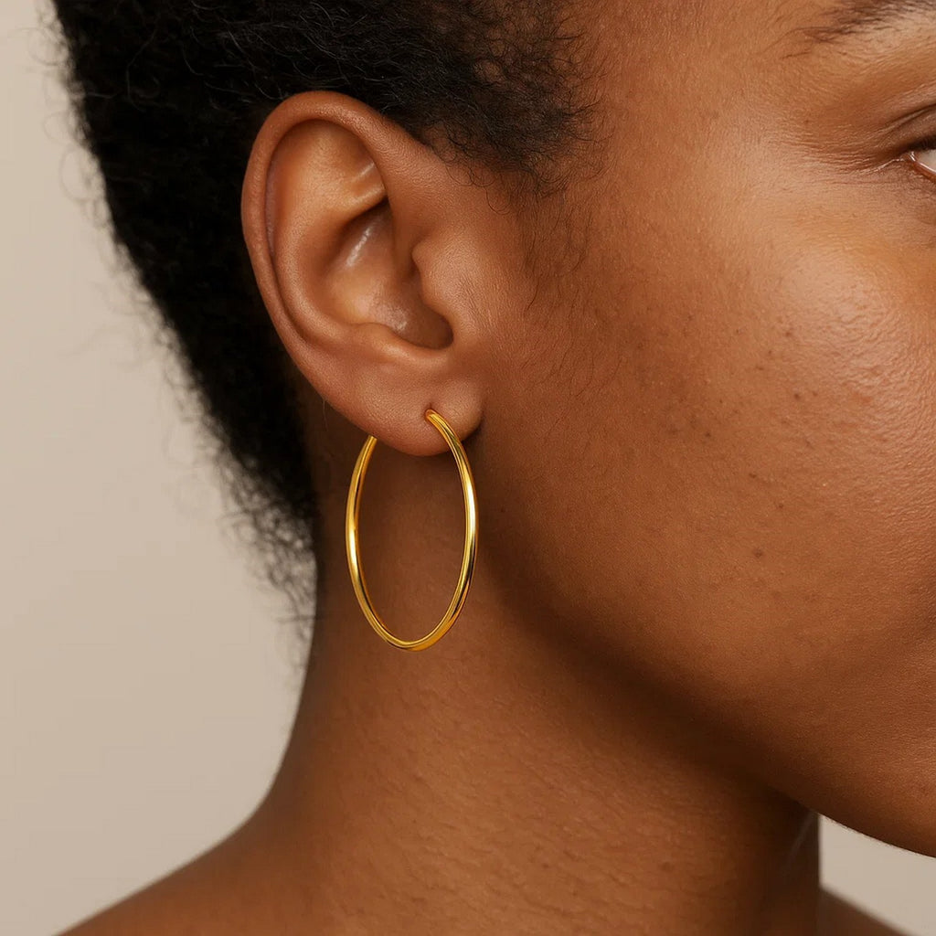 Close-up of a 25mm 14K yellow gold hoop on the ear, showing its size against the lobe