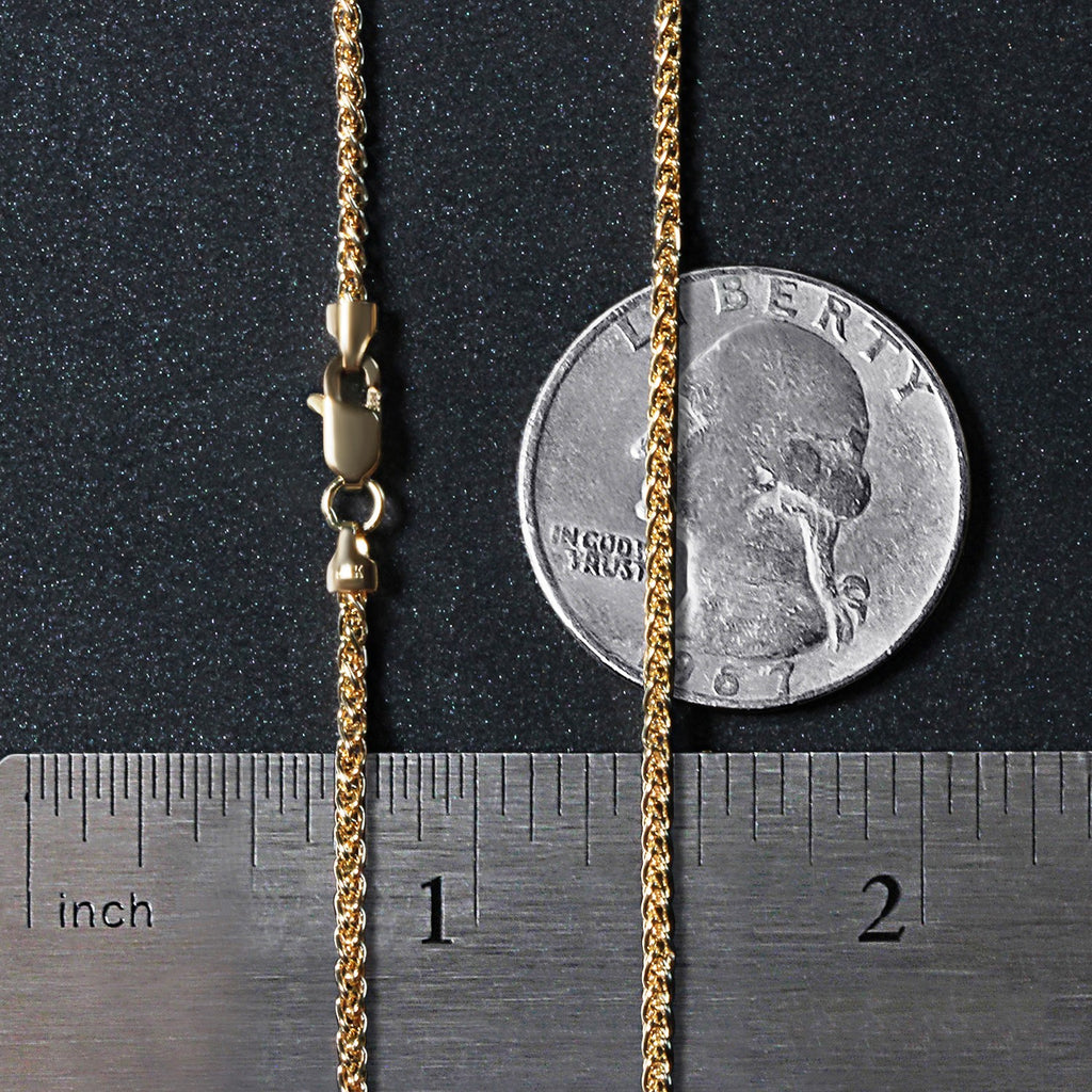 1.5mm wheat chain in 14K yellow gold beside an inch ruler and a coin for scale