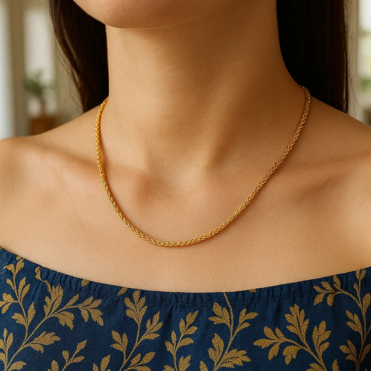 1.5mm wheat chain in 14K yellow gold worn with a navy patterned top