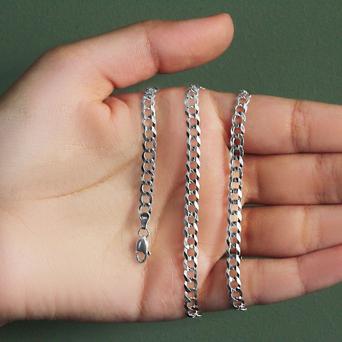 4.70mm curb chain in 14K white gold held across an open palm