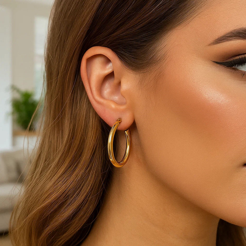 Close-up of a 30mm 4mm-wide 14K yellow gold hoop on the ear