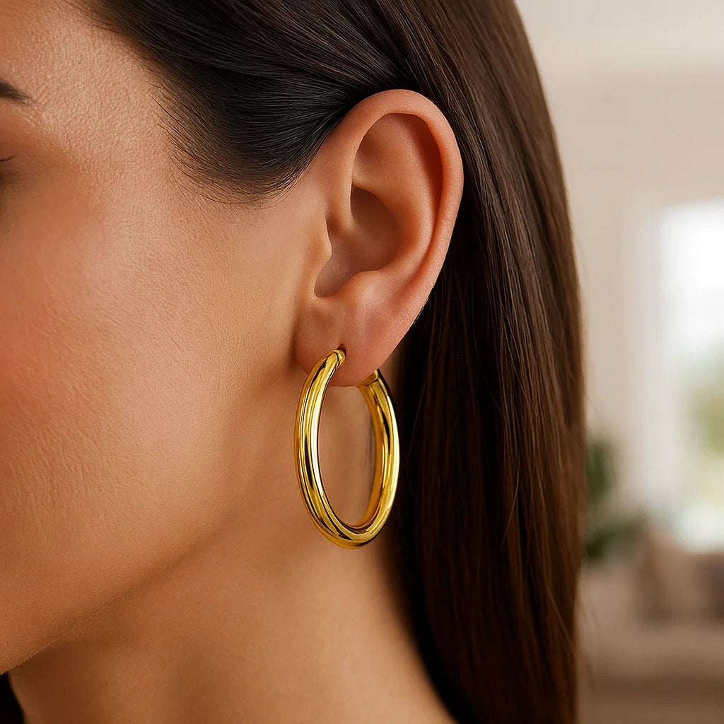 Close-up of a 40mm 5mm-wide 14K yellow gold hoop on the ear