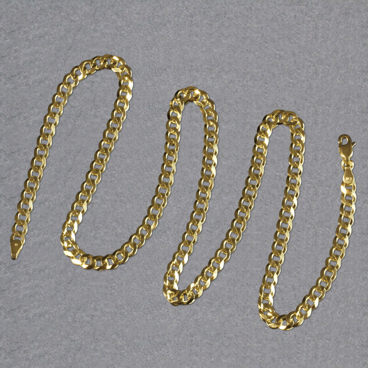 Curb chain in 14K yellow gold laid out in loops
