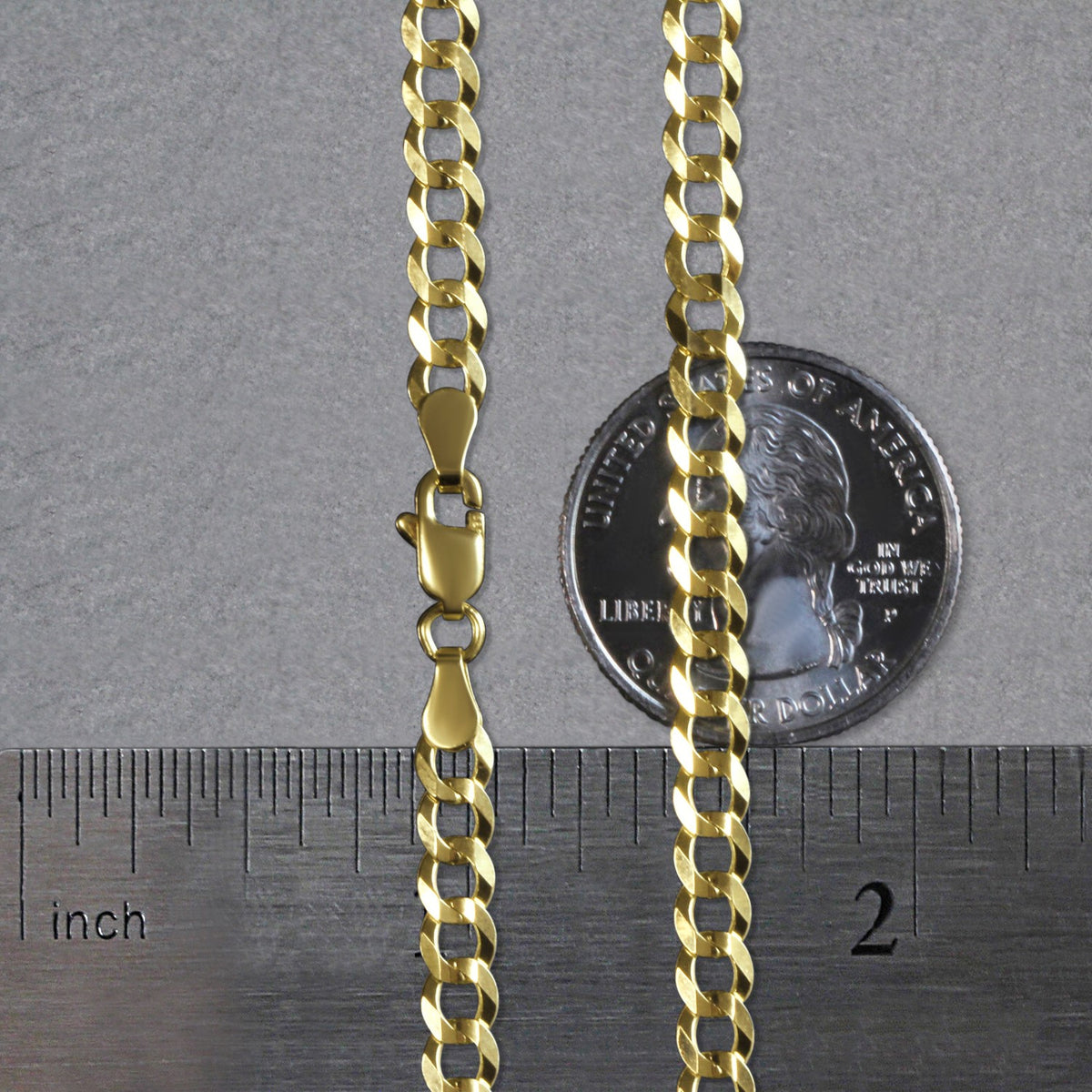 4.70mm curb chain in 14K yellow gold beside an inch ruler and a coin for scale