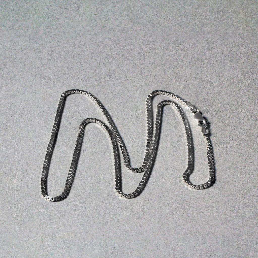 Box chain in 14K white gold laid out in loops