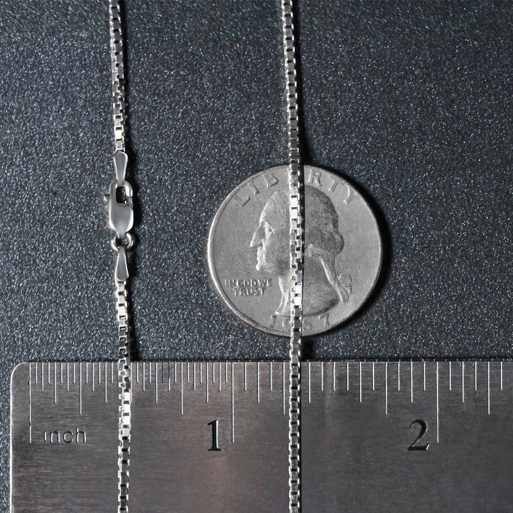 1.4mm box chain in 14K white gold beside an inch ruler and a coin for scale