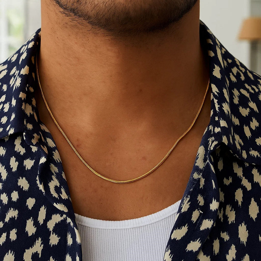 Snake chain in 14K yellow gold worn with a patterned open shirt