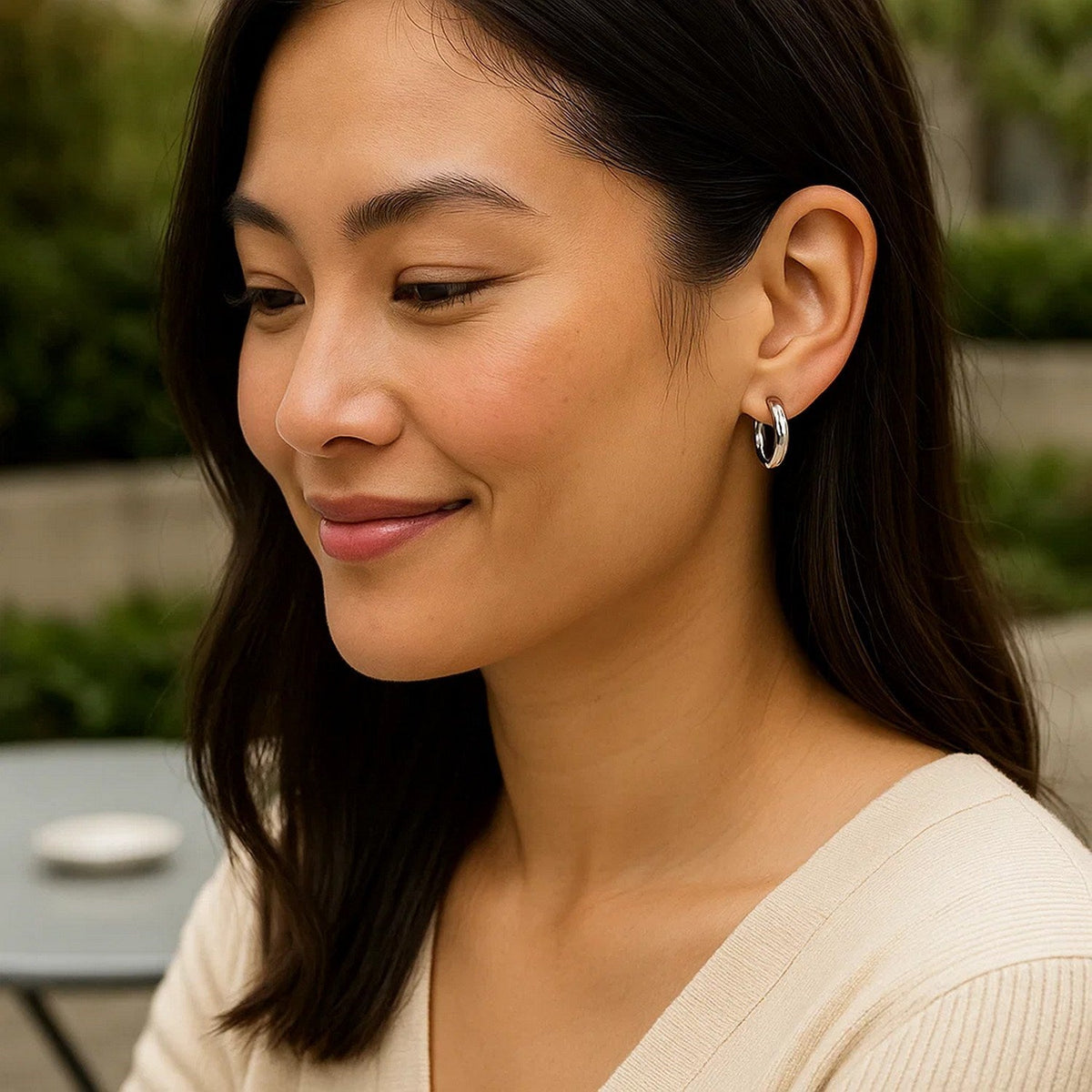 15mm 14K white gold hoop worn with a white top outdoors