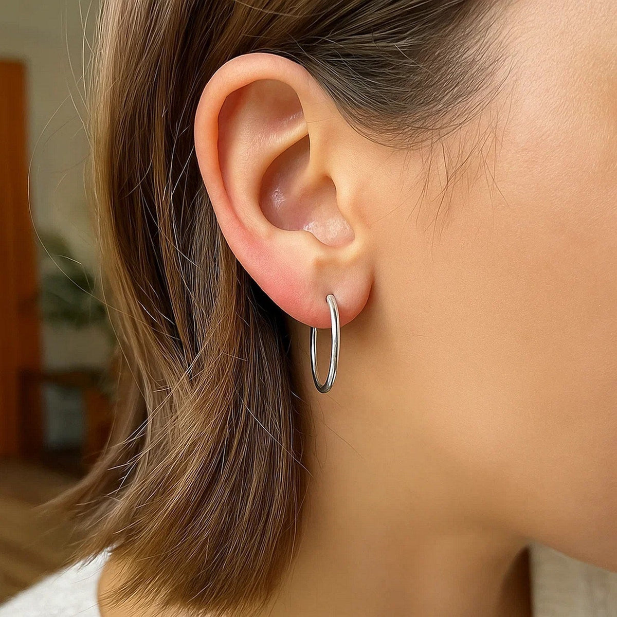 Close-up of a 25mm 14K white gold hoop on the ear
