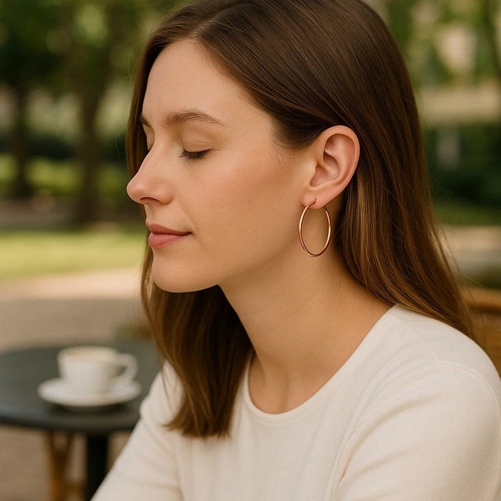 25mm 14K rose gold hoop worn at a café table