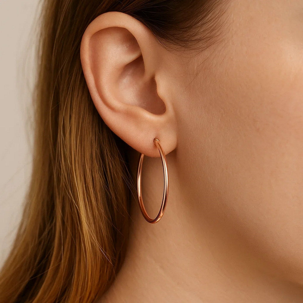 Close-up of a 25mm 14K rose gold hoop on the ear