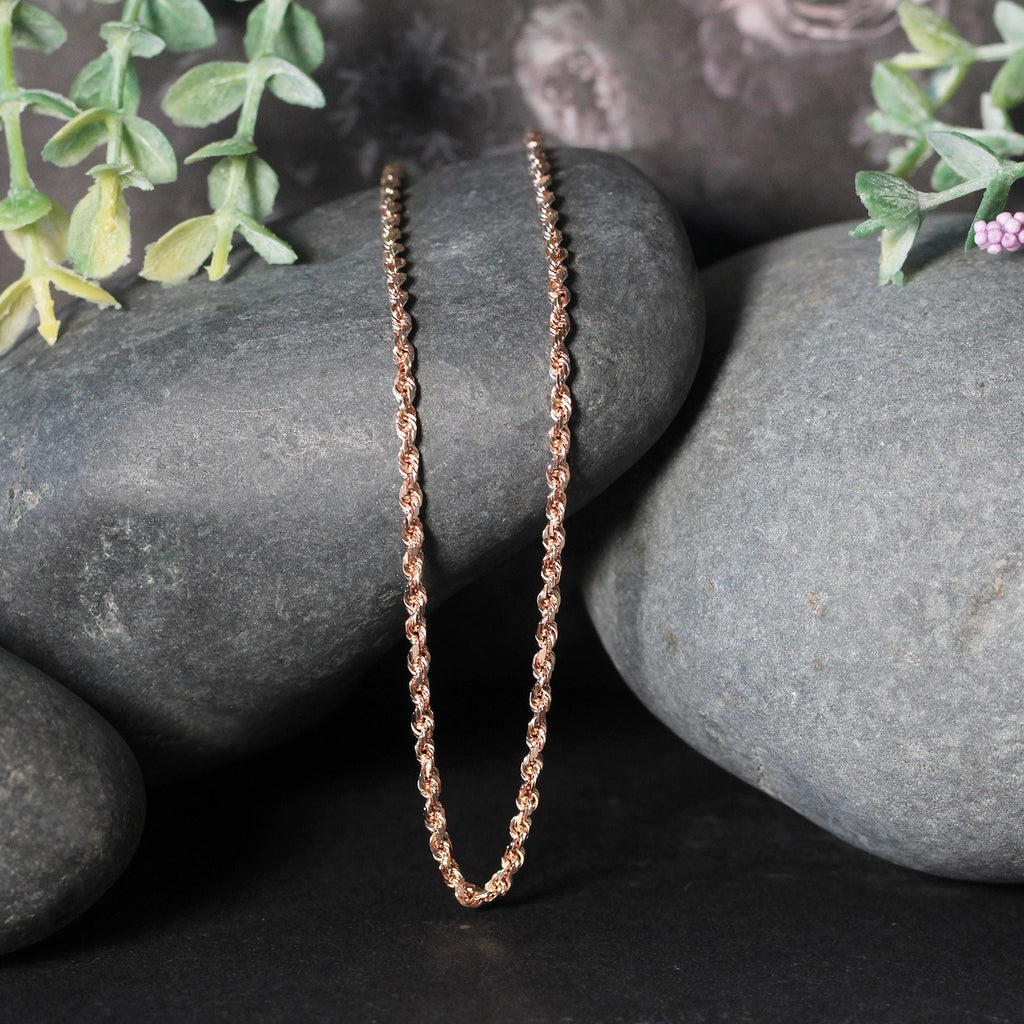 Rope chain in 14K rose gold draped over two stones