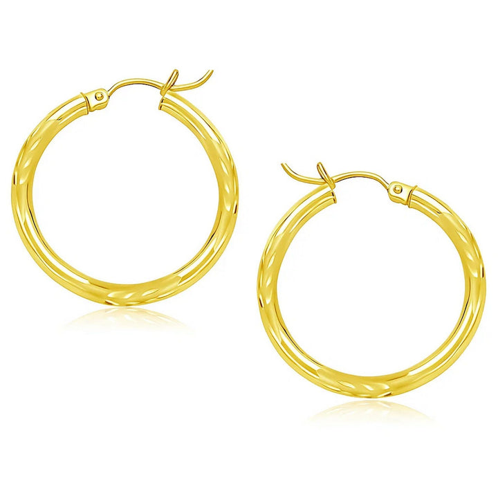 Diamond-cut hoop earrings in 14K yellow gold, 25mm, showing the faceted surface