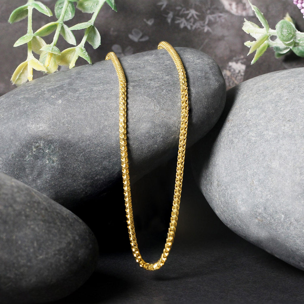 Franco chain in 14K yellow gold draped over two stones