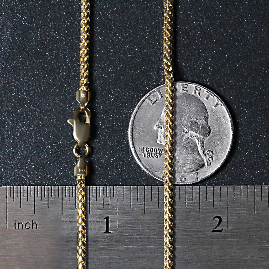 2.20mm Franco chain in 14K yellow gold beside an inch ruler and a coin for scale