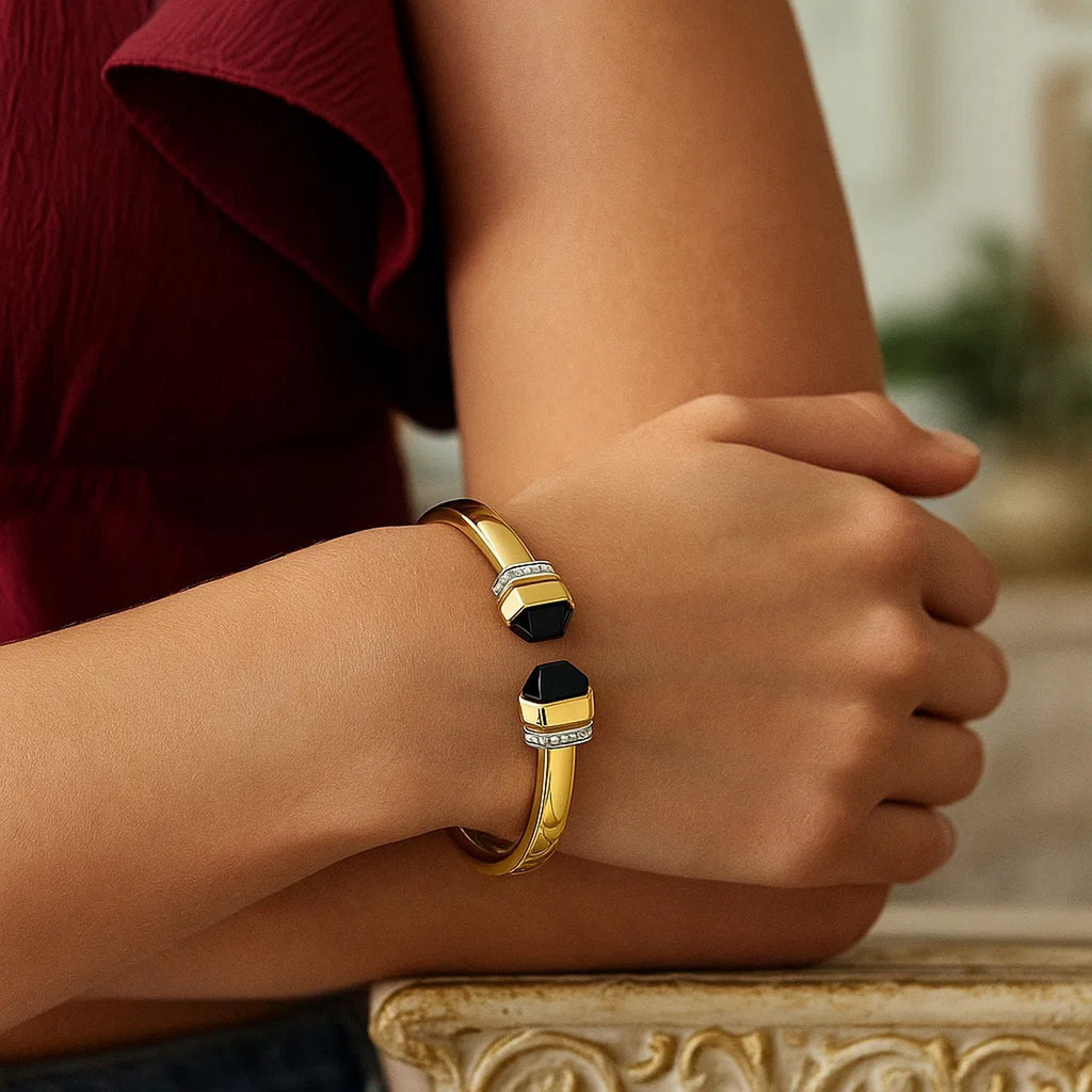 Black onyx open cuff in 14K yellow gold worn on the wrist