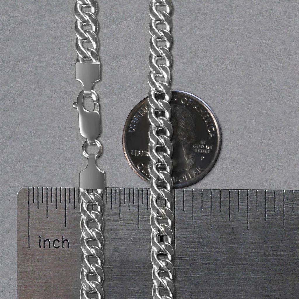 5.50mm Miami Cuban chain in 14K white gold beside an inch ruler and a coin for scale