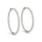 Front view of 14K white gold diamond hoop earrings with shared prong setting