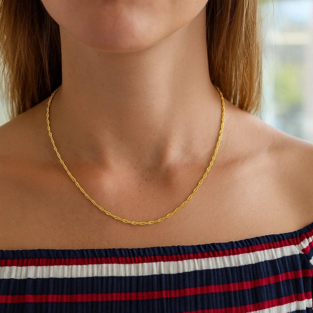 Singapore chain in 14K yellow gold worn with a striped top