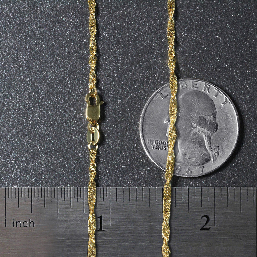 1.80mm Singapore chain in 14K yellow gold beside an inch ruler and a coin for scale