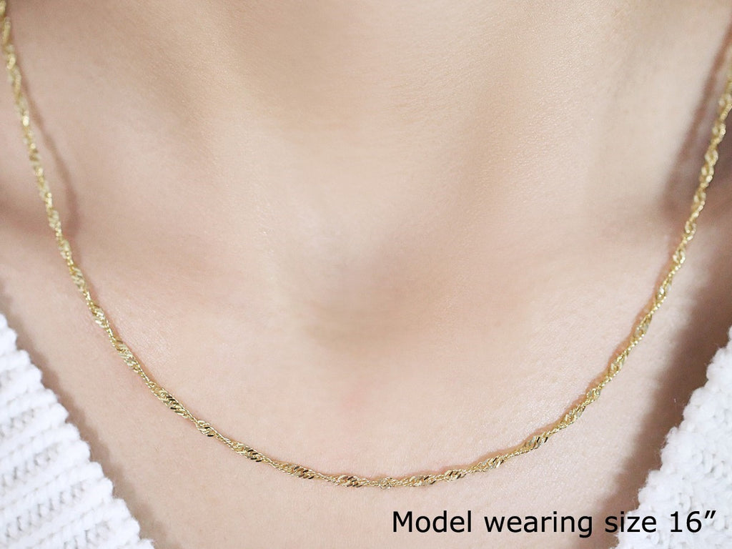 Singapore chain in 14K yellow gold worn close to the neck at 16 inches