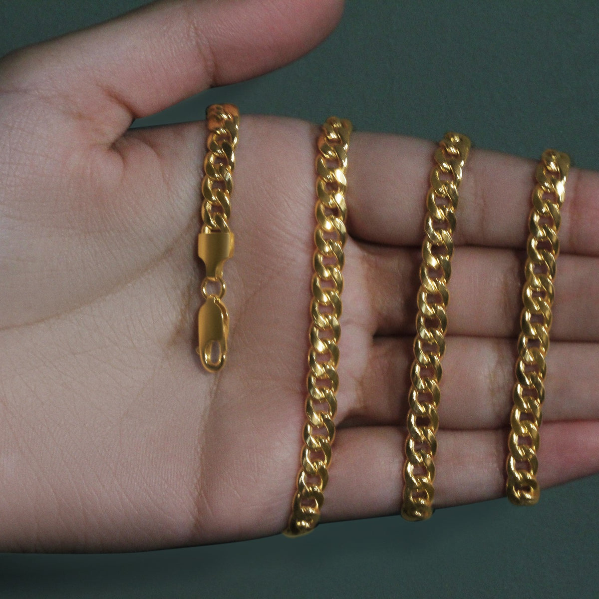 5.50mm Miami Cuban chain in 14K yellow gold held across an open palm