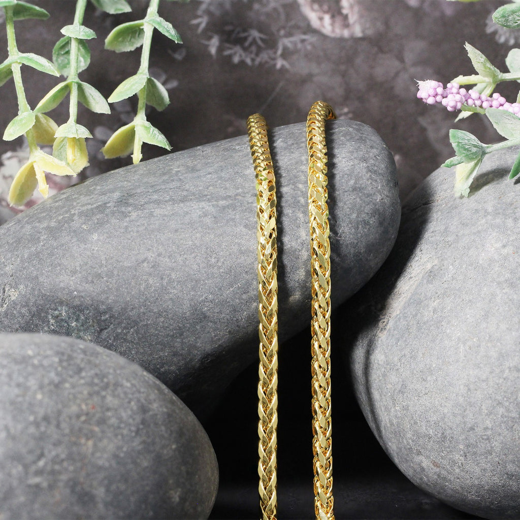 Franco chain in 14K yellow gold draped over two stones