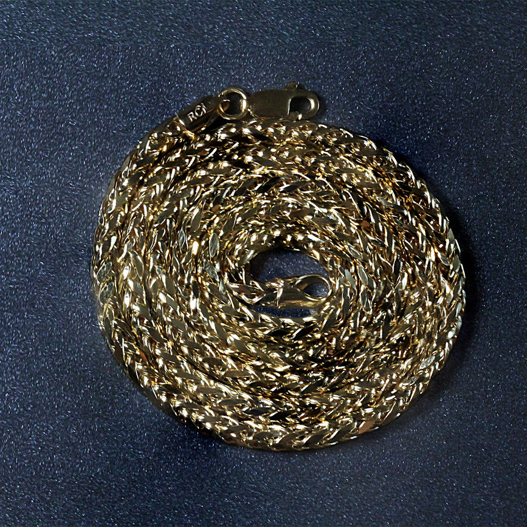 14K yellow gold Franco chain, 3.20mm, coiled on a dark surface