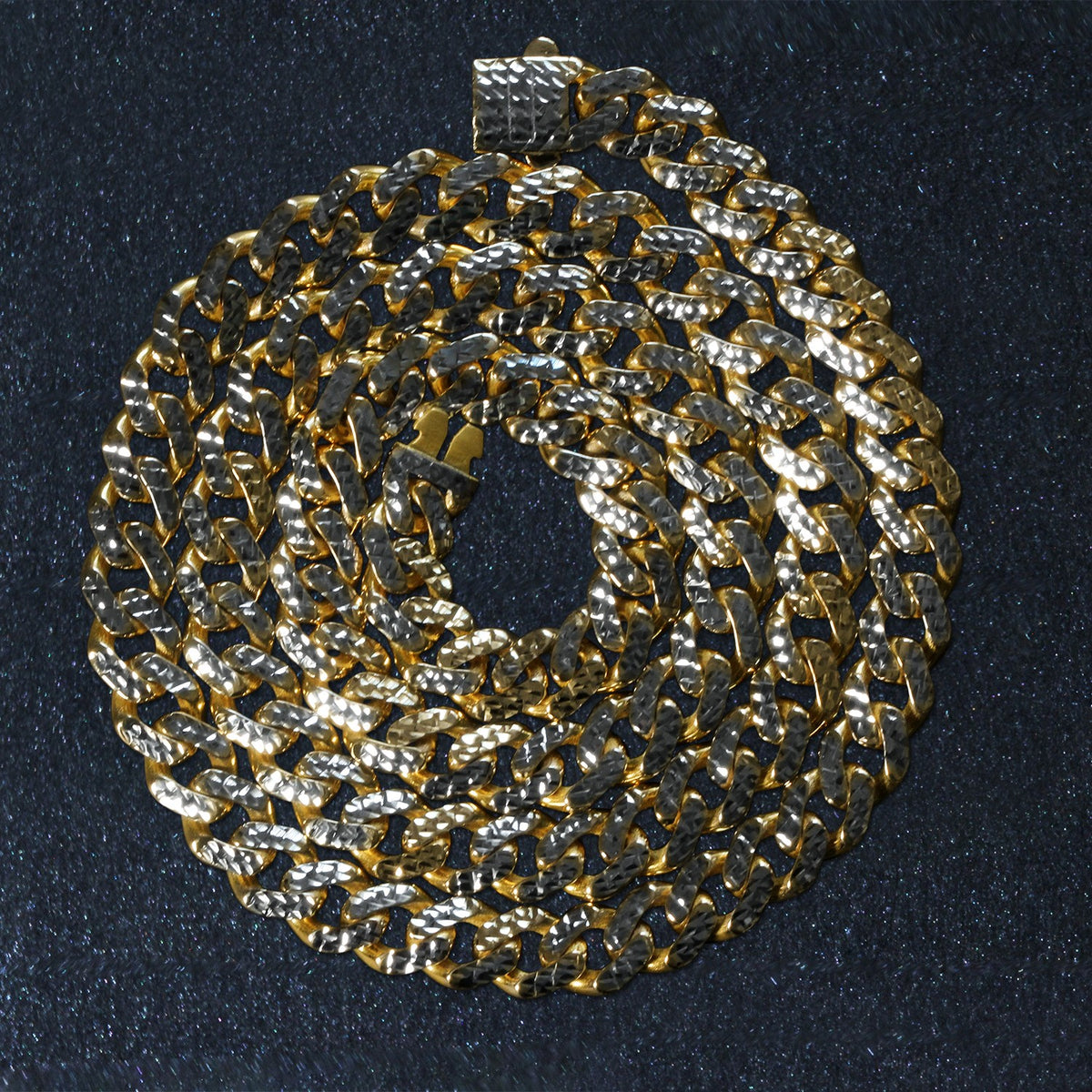 14K two-tone gold Miami Cuban chain, 8.00mm, coiled on a dark surface