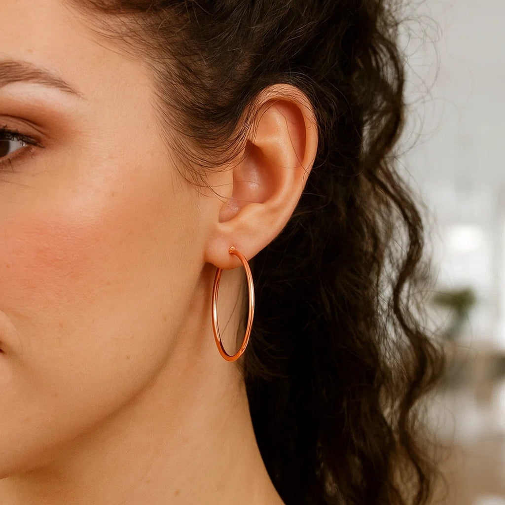 Close-up of a 40mm 14K rose gold hoop on the ear