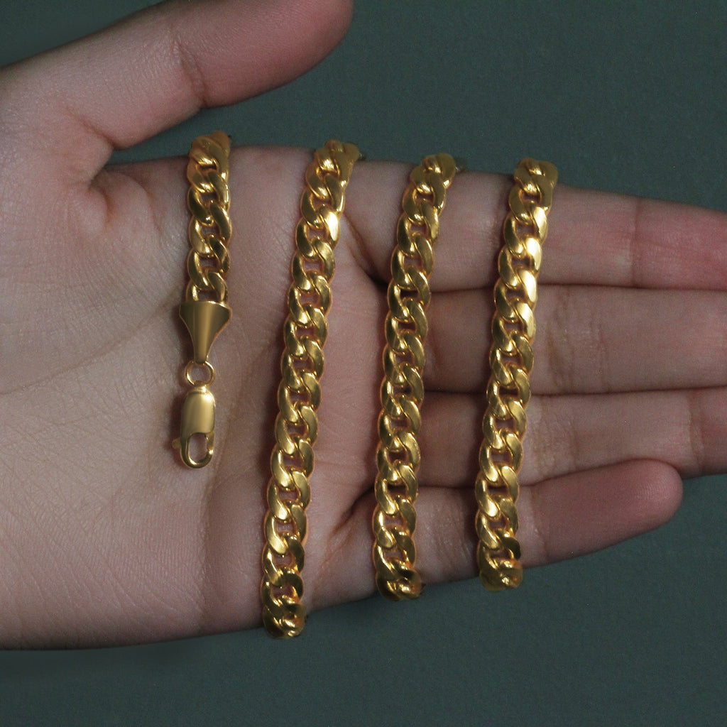 7.00mm Miami Cuban chain in 14K yellow gold held across an open palm