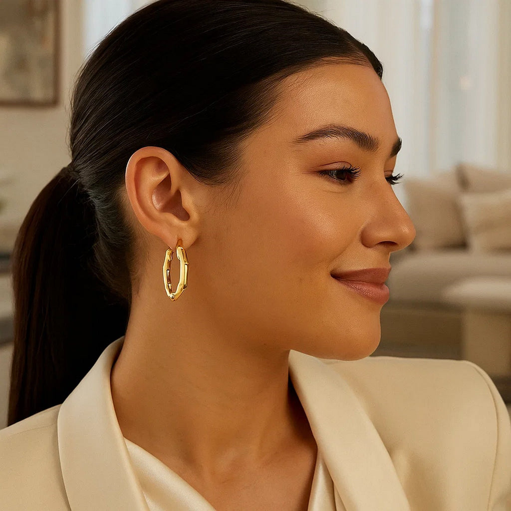 Bamboo hoop in 14K yellow gold worn with a cream blazer