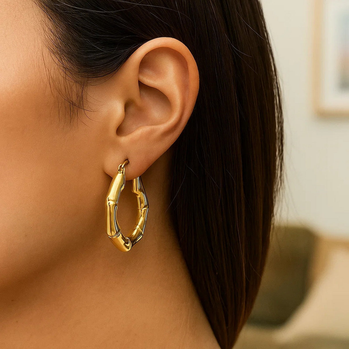 Close-up of a 14K yellow gold bamboo hoop on the ear