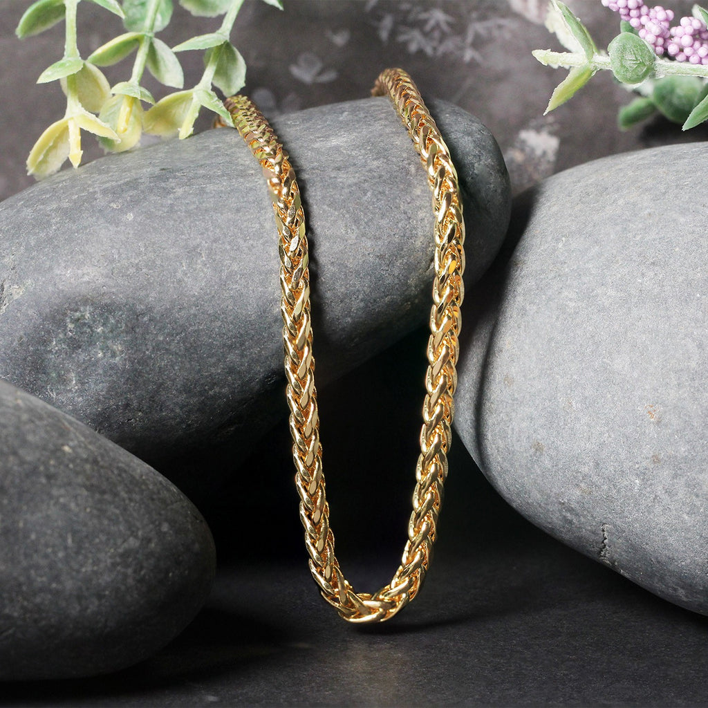 Franco chain in 14K yellow gold draped over two stones
