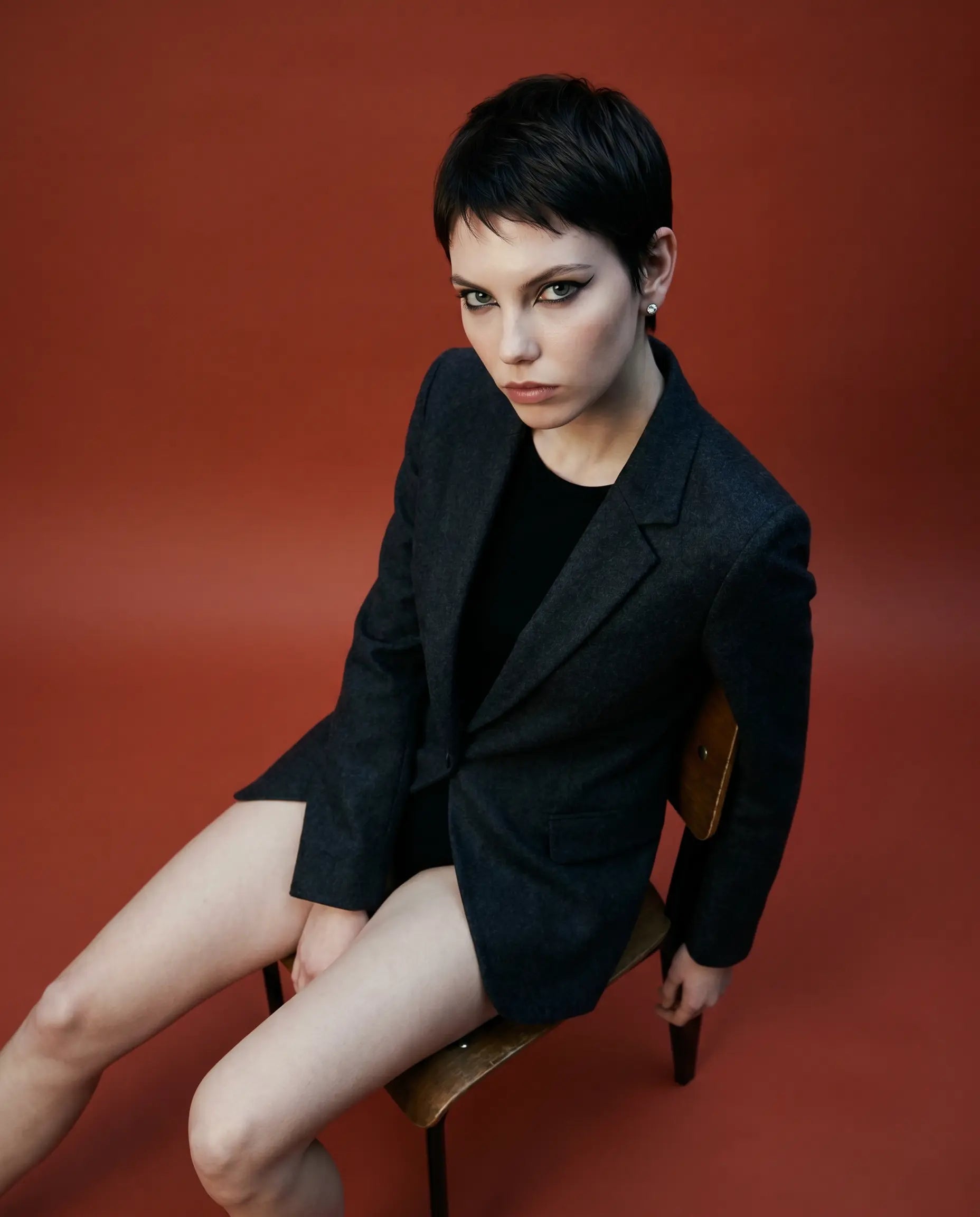 Deeve Canada Model wearing 4 carat IGI certified lab grown diamond stud earrings in 14k white gold wearing  black dress on a rust orange background 