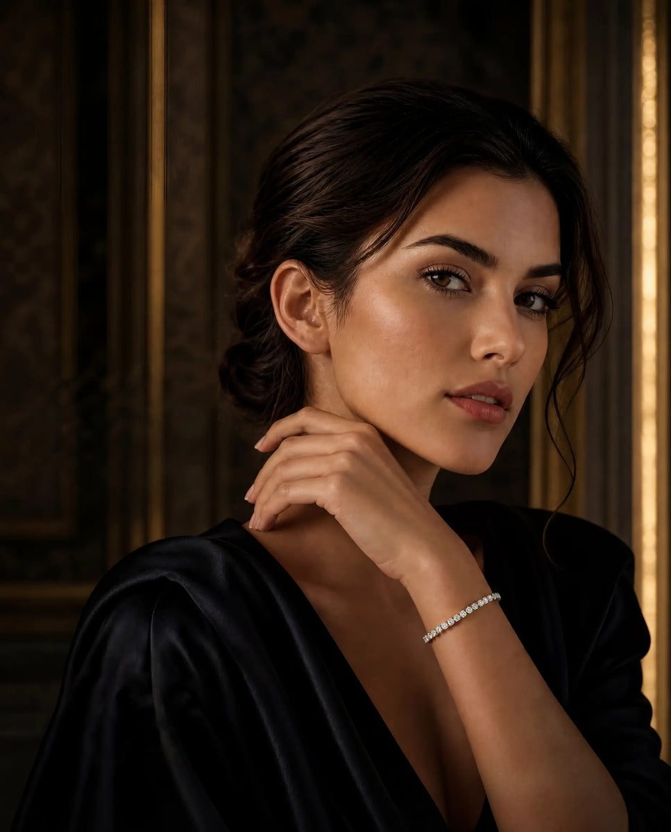 Woman wearing lab grown diamond tennis bracelet in 14k gold from Deeve Canada in black top with a blurred background