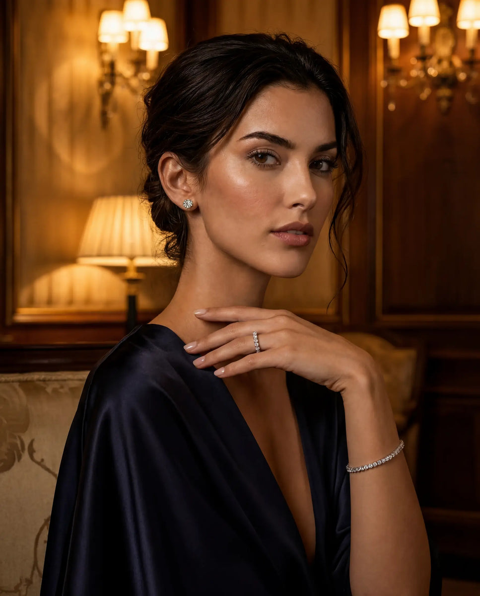 Woman wearing jewelry in a dimly lit room with chandeliers wearing Deeve's IGI certified lab grown diamond set