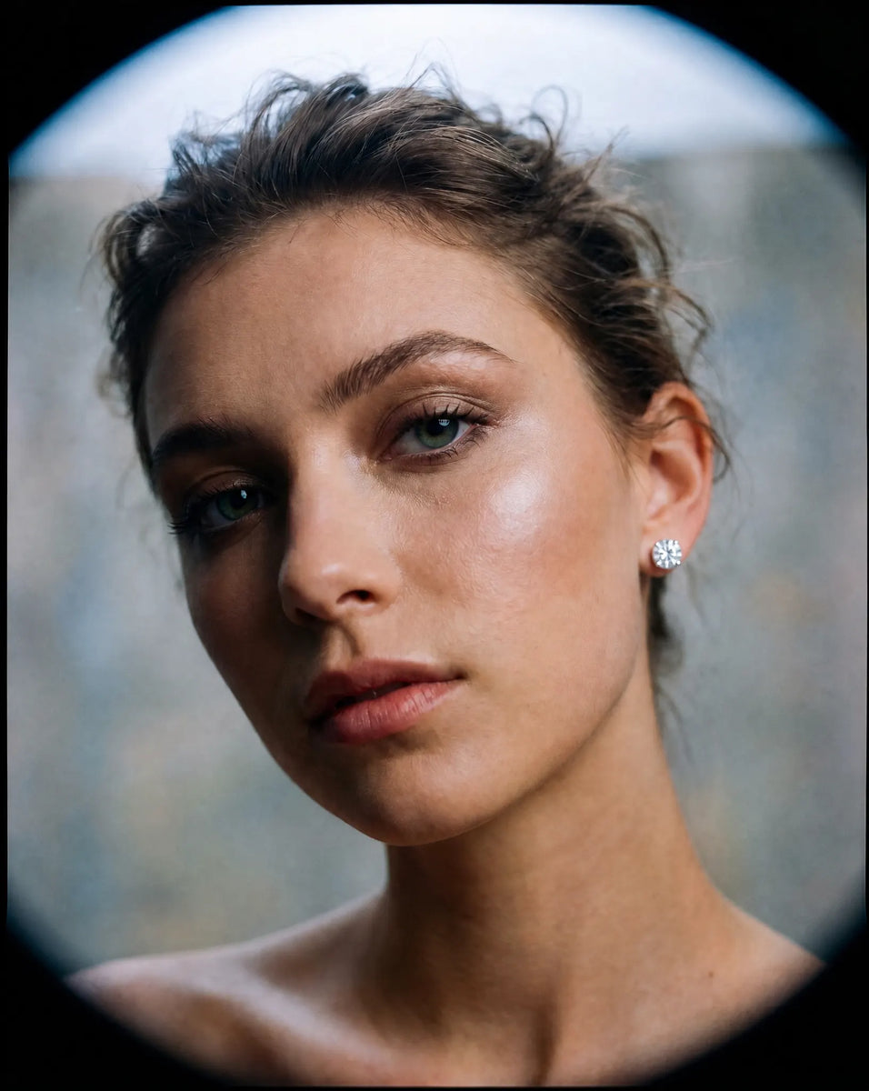 Close-up of a Deeve's model face wearing a 4 carat IGI certified lab grown diamond stud earrings with a blurred background