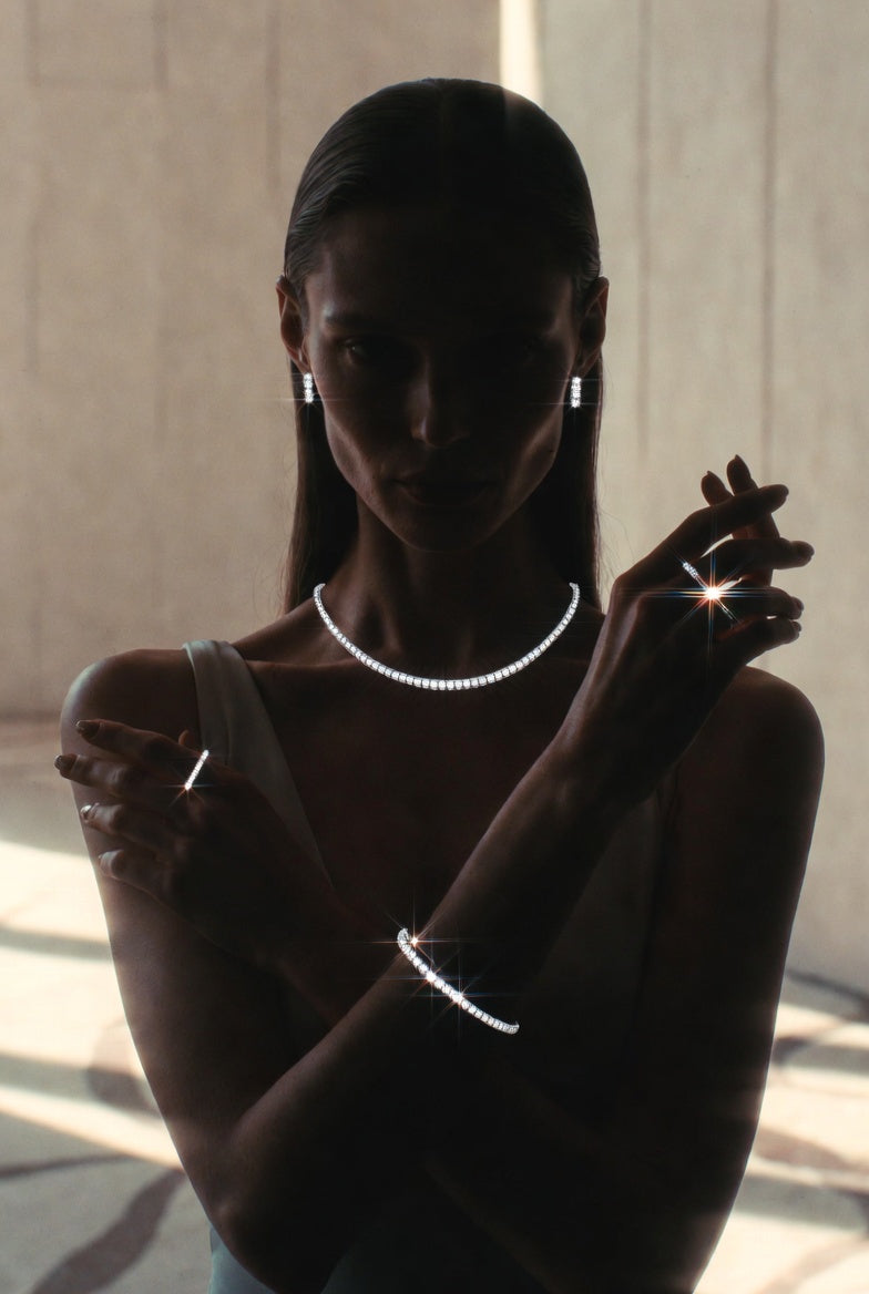 Silhouette of a person wearing jewelry against a neutral background