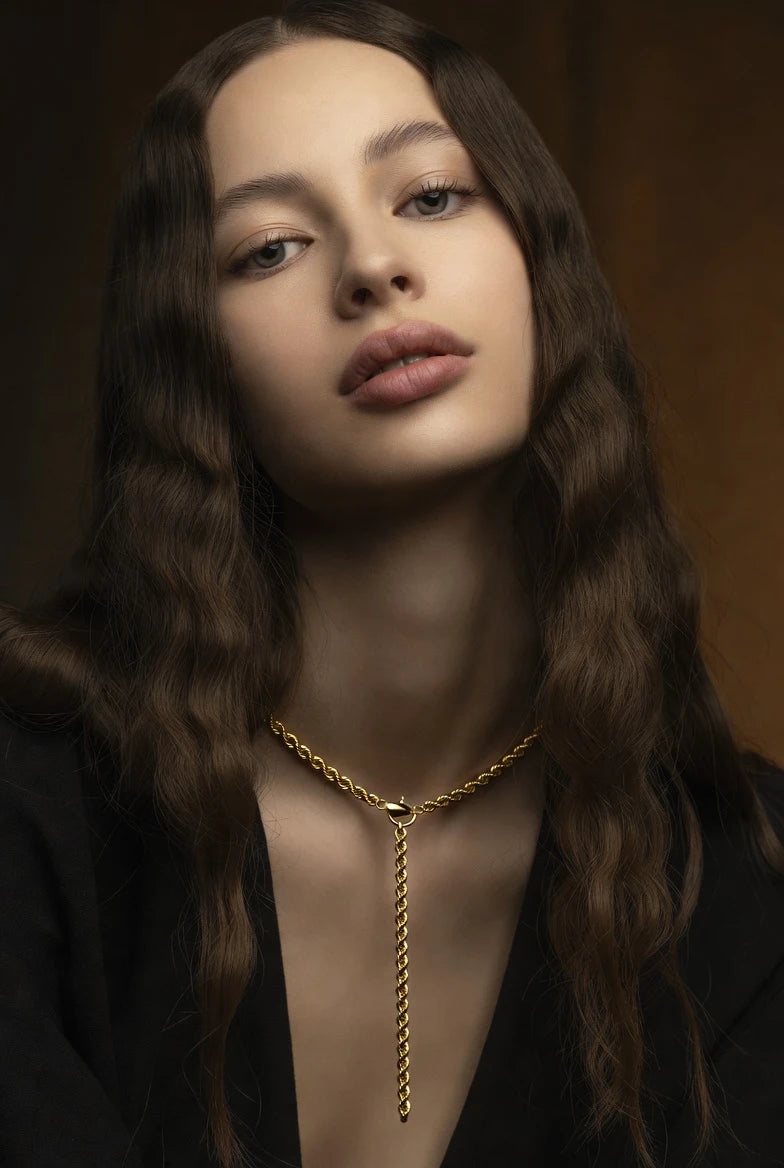 model from Deeve jewelry Canada wearing a 14K yellow gold luxury chain necklace on a dark background 